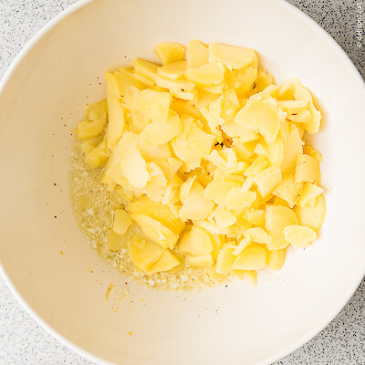 Kartoffelsalat: Pellkartoffeln schneiden und noch warm ins Dressing geben