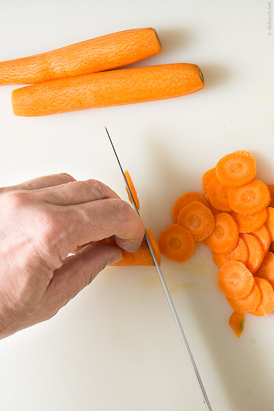 Geschälte Karotten werden in zwei Millimeter dünne Scheiben geschnitten