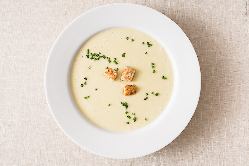Vichyssoise, kalte Suppe aus Lauch und Kartoffeln, angerichtet in Suppenteller, bestreut mit Schnittlauch und Croûtons